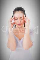 Composite image of brunette suffering from migraine