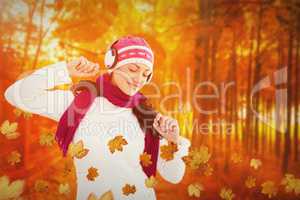 Composite image of winter brunette listening to music