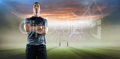 Composite image of full length of confident rugby player with arms crossed