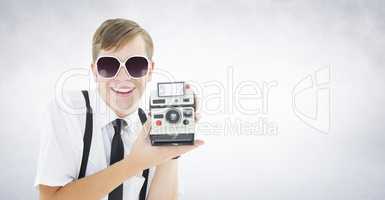 Composite image of geeky hipster holding a retro camera