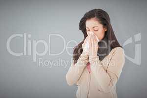 Composite image of sick brunette blowing her nose