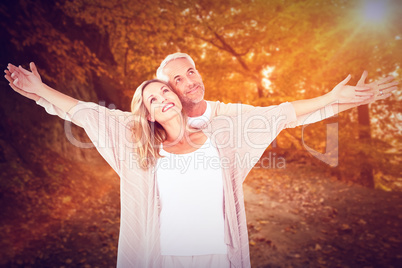 Composite image of cheerful couple with arms outstretched