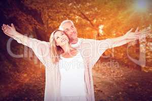 Composite image of cheerful couple with arms outstretched