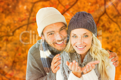 Composite image of attractive couple in winter fashion smiling a