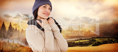 Composite image of attractive brunette looking up wearing warm c