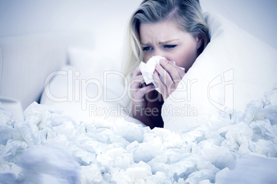 Composite image of blonde woman sneezing