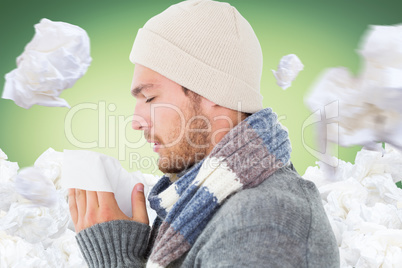 Composite image of handsome man in winter fashion blowing his no