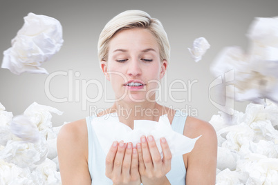 Composite image of sick woman holding tissues