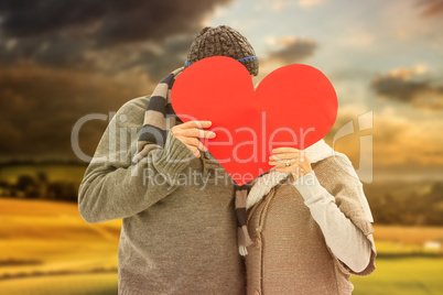 Composite image of happy mature couple in winter clothes holding