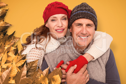 Composite image of happy couple in warm clothing