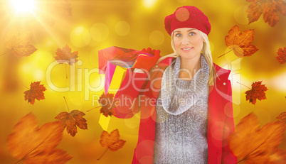 Composite image of blonde in winter clothes holding shopping bag