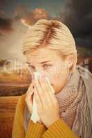 Composite image of close up of woman blowing her nose