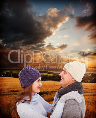 Composite image of happy couple in warm clothing