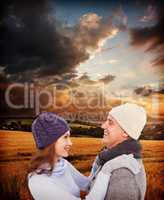 Composite image of happy couple in warm clothing