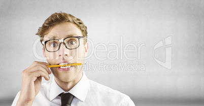 Composite image of geeky businessman biting a pencil
