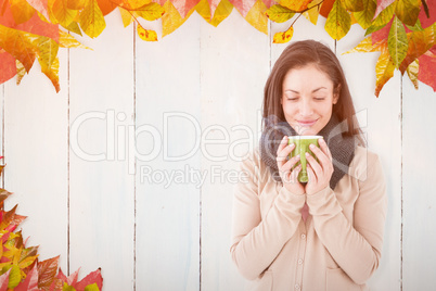 Composite image of smiling brunette smelling hot beverage