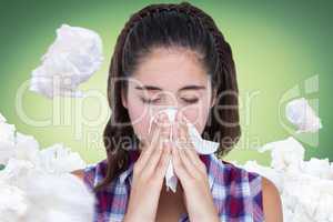 Composite image of close-up of sick woman sneezing in a tissue