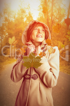 Composite image of smiling beautiful woman in winter coat lookin