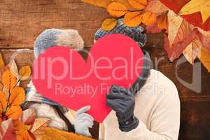 Composite image of attractive young couple in warm clothes holdi