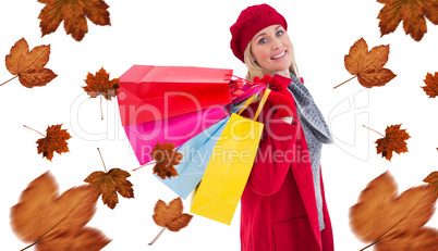 Composite image of blonde in winter clothes holding shopping bag