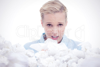 Composite image of blonde sick woman holding lots of tissues