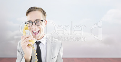 Composite image of geeky businessman talking on retro phone