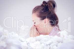 Composite image of young woman blowing her nose