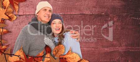 Composite image of couple in warm clothing embracing
