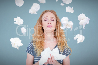 Composite image of sick blonde woman holding paper tissue