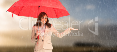 Composite image of happy businesswoman holding umbrella