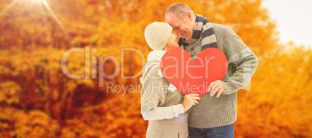 Composite image of happy mature couple in winter clothes holding