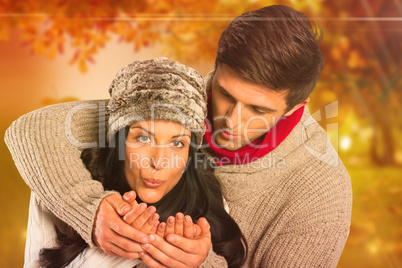 Composite image of young couple blowing over hands