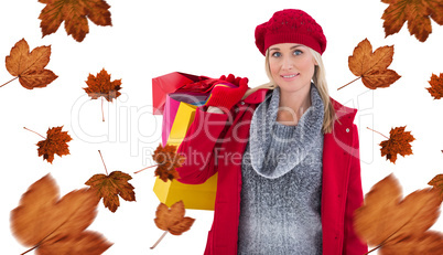 Composite image of blonde in winter clothes holding shopping bag