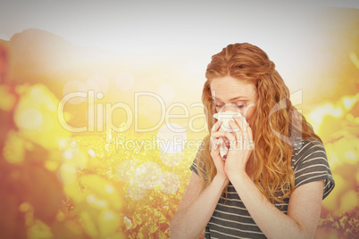 Composite image of sick blonde woman blowing her nose