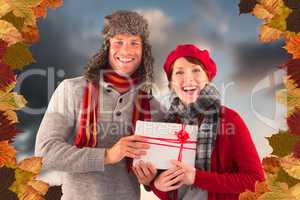 Composite image of couple smiling and holding gift