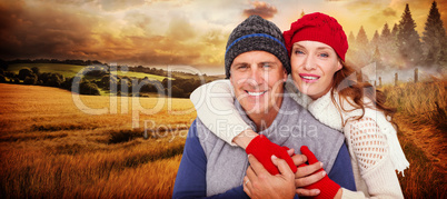 Composite image of happy couple in warm clothing