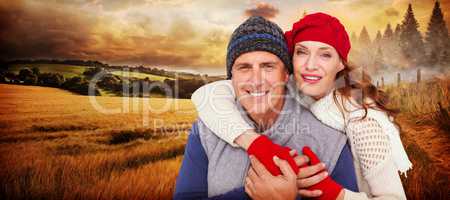 Composite image of happy couple in warm clothing