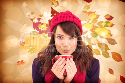 Composite image of festive brunette holding a mug