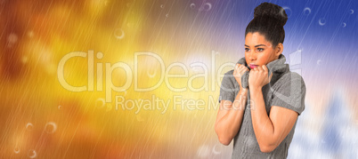 Composite image of pretty girl in winter jumper shivering