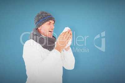 Composite image of sick man in winter fashion sneezing