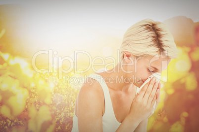 Composite image of sick woman blowing her nose