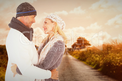 Composite image of happy husband holding wife while looking at e