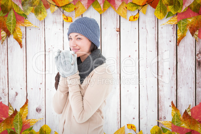 Composite image of smiling brunette drinking hot beverage