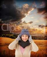 Composite image of smiling brunette wearing warm clothes