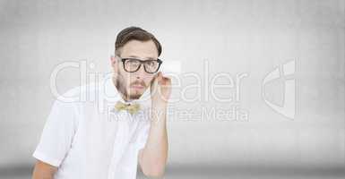 Composite image of geeky businessman eavesdropping with cup