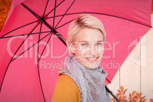 Composite image of smiling woman holding an umbrella