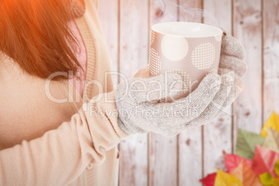 Composite image of woman holding polka dotted mug