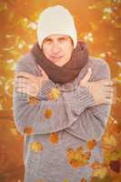 Composite image of casual man shivering in warm clothing