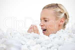 Composite image of blonde woman sneezing with hands in front of