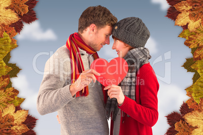 Composite image of couple holding a red heart